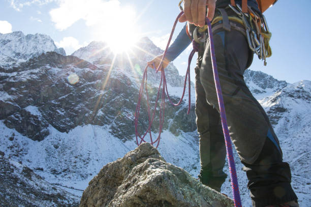 низкий угол зрения альпиниста с веревкой в горах - travel adventure winter cold стоковые фото и изображения