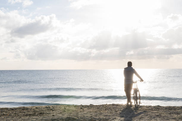 istock Man explores mediterranean beach at sunrise 956845416