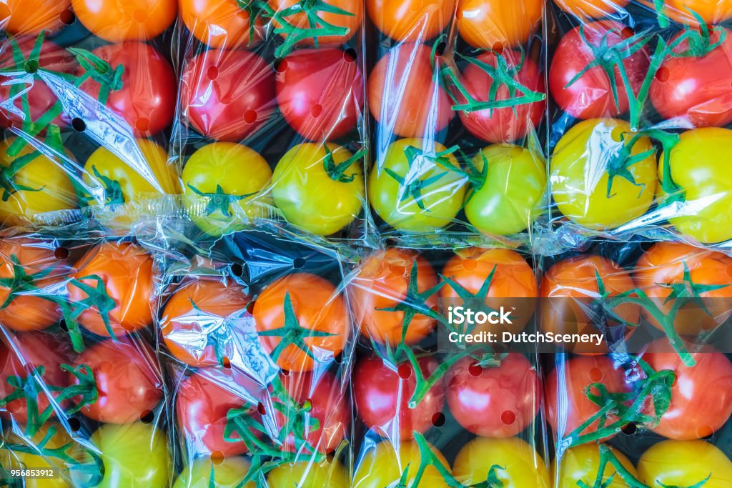 Display of fresh plastic wrapped cherry tomatoes Display of fresh plastic wrapped yellow, orange and red cherry tomatoes Plastic Stock Photo