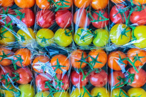 display of fresh plastic wrapped cherry tomatoes - pacote plastico imagens e fotografias de stock