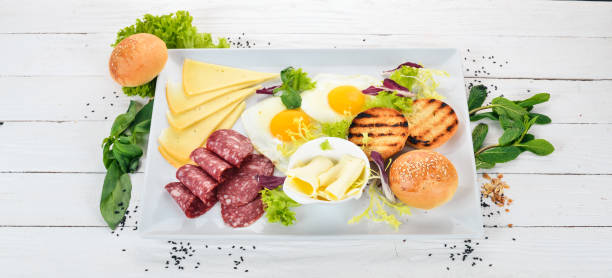 istock Breakfast. Eggs with bacon and tomatoes, toast bread. Top view. On a wooden background. Copy space. 956854302