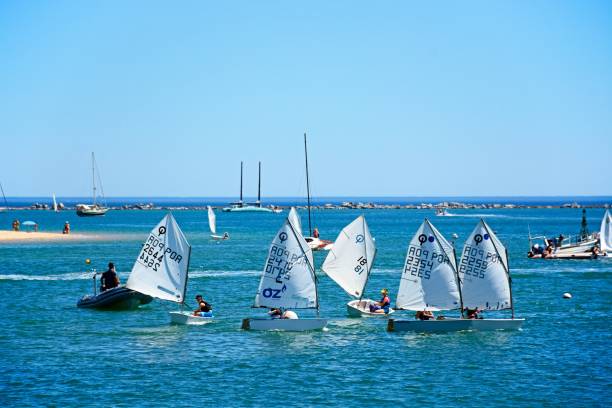 Optimist dinghies, Ferragudo, Portugal. People sailing in Optimist dinghy boats on the river Arade, Ferragudo, Algarve, Portugal, Europe. sailing dinghy stock pictures, royalty-free photos & images