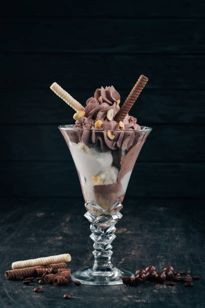 istock Chocolate ice cream with nuts. On a black wooden background. Copy space. 956855592
