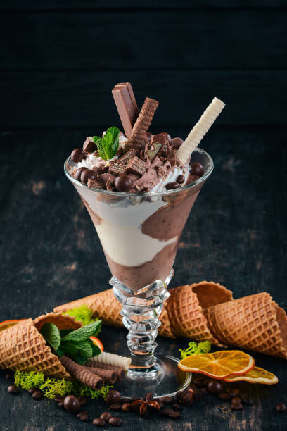 istock Ice cream with milk chocolate. On a black wooden background. Copy space. 956859068