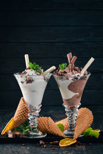 istock Two servings of ice cream. On a black wooden background. Copy space. 956860682