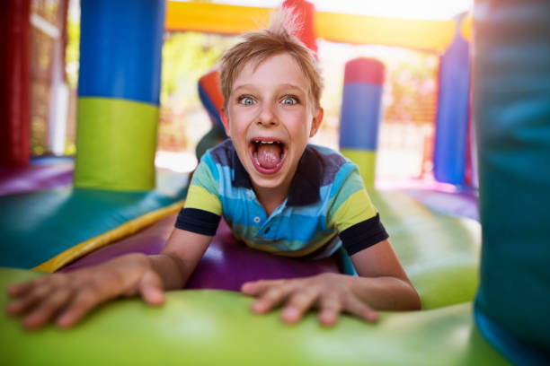 Little boy having fun in inflatable castle playground