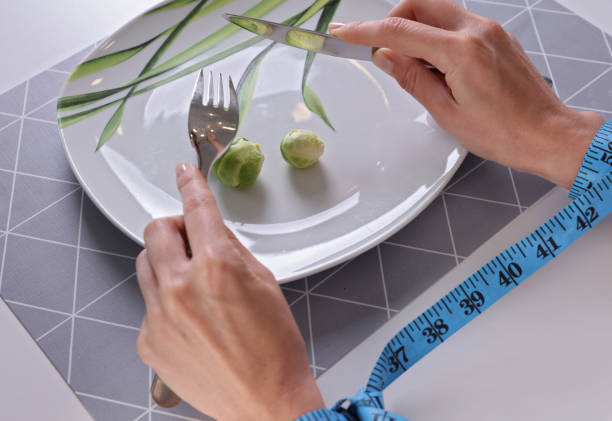 istock Eating disorder concept. Young woman suffering from anorexia being on restricted diet 956861556