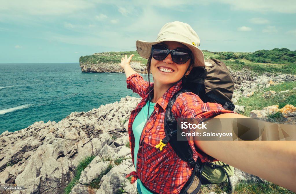 Voyageur Routard femme heureuse prendre une photo de selfie sur la magnifique côte de l’océan - Photo de Selfie libre de droits