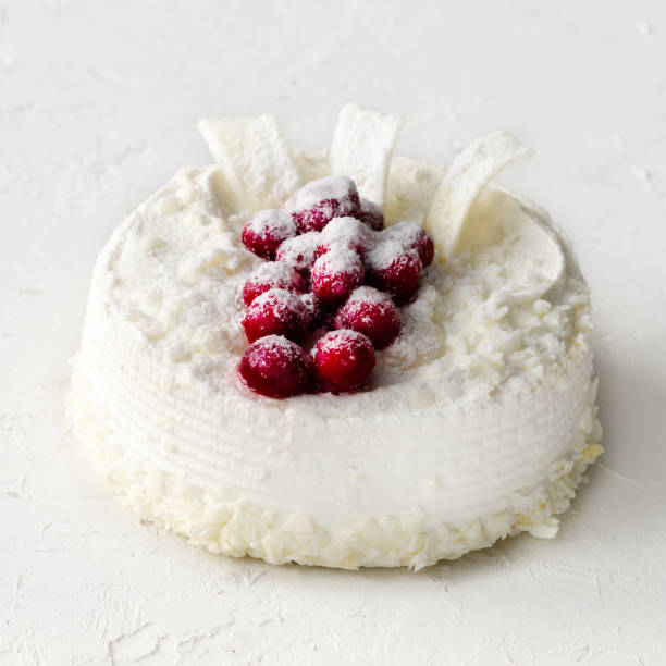 istock Delicious cheesecakes with cranberries, cherries, coconut flakes and white chocolate on light concrete background. Copyspace 956870486