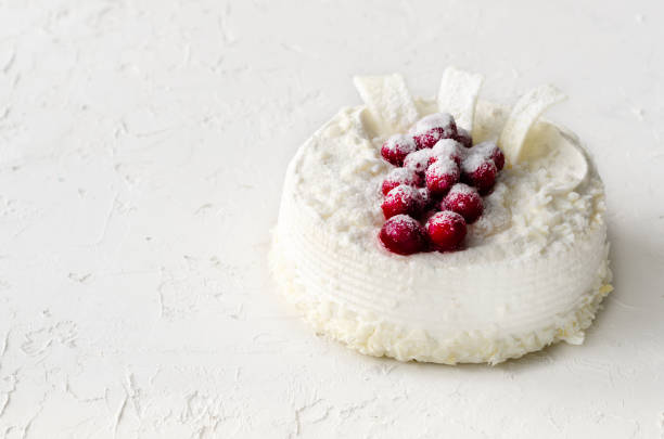 istock Delicious cheesecakes with cranberries, cherries, coconut flakes and white chocolate on light concrete background. Copyspace 956870514