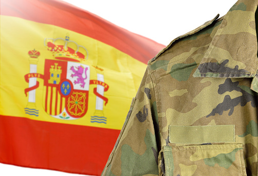 Military man posing in front of Spain flag