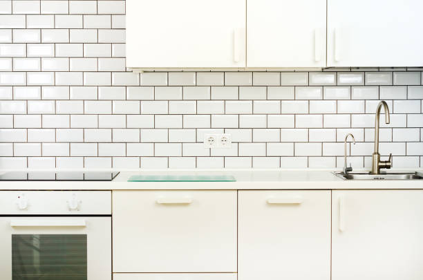 istock White interior design, modern and minimalist style kitchen with household appliances. Open space in living room full of light. Copyspace 956874378
