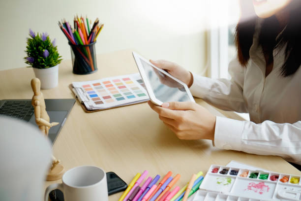 istock Designer female working with tablet on desk in studio. 956878350
