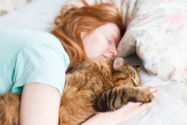istock Young redhair woman sleeping with cat 956878568