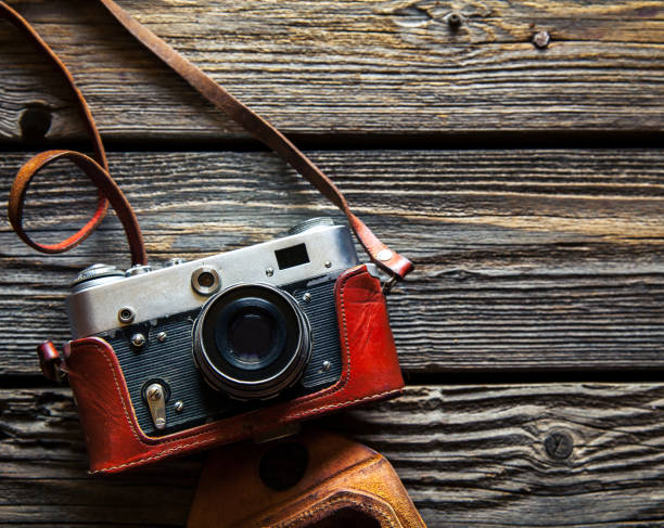 istock Retro camera on wood table background, vintage color tone 956878654