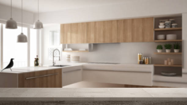 istock Wooden vintage table top or shelf closeup, zen mood, over blurred modern kitchen, white architecture interior design 956885022