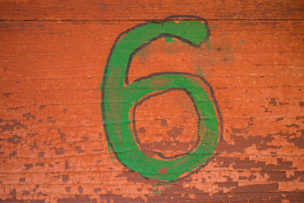 istock Green number six on a brown wall texture for a background. Old peeling paint 956885150
