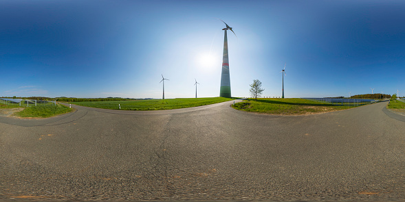 360 degrees spherical panoramic shot of wind turbines and modern solar panels in a rural landscape
