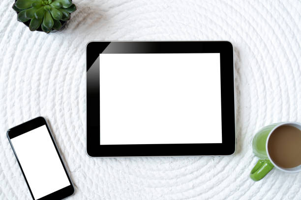 istock Office table with tablet, computer, coffee cup and flower. View from above with copy space 956885328