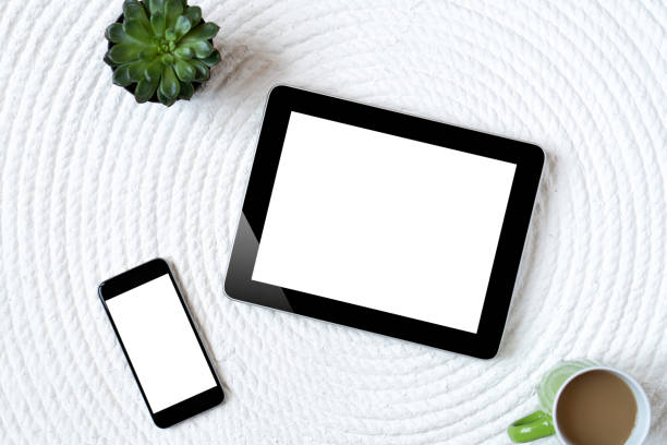 istock Office table with tablet, computer, coffee cup and flower. View from above with copy space 956885442