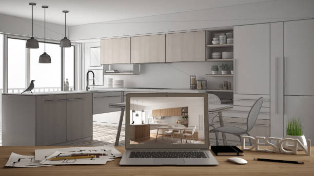 istock Architect designer desktop concept, laptop on wooden work desk with screen showing interior design project, blueprint CAD sketch in the background, modern kitchen idea template 956885638