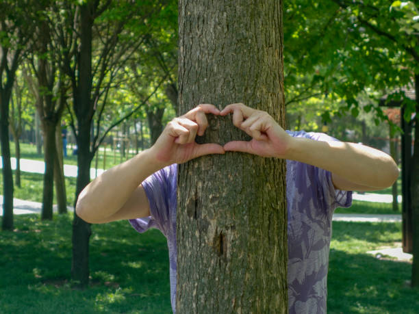 Woman protects a tree by showing heart gesture
