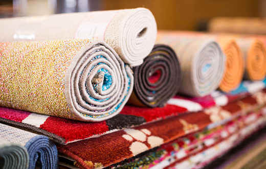 Stack of traditional  colorful carpets in carpet shop, nobody