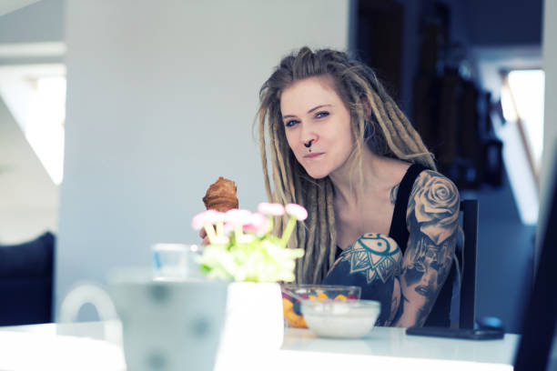 istock Young tattooed woman is taking her breakfast at home 956887882