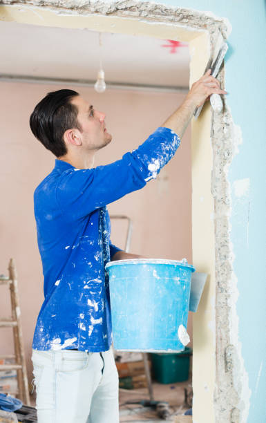 istock Plasterer renovating indoor doorway 956888392