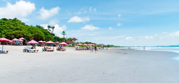 People sunbathing at the beach of Seminyak, Bali, Indonesia, during a hot day in the summer.