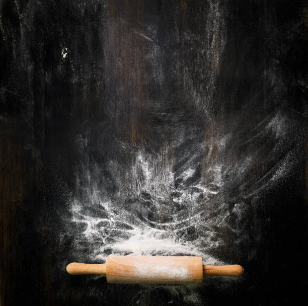 istock Banner. Baking background with free space for your text. Rolling pin and flour on black table. Copy space. Top view 956903158