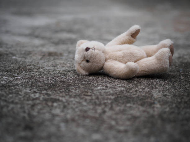 istock eddy bear is laying down on the floor. lonely concept. international missing children's day. 956906106
