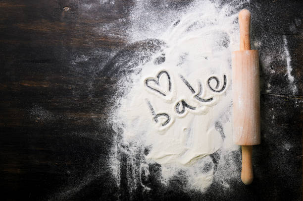 istock Baking background. Heart of flour, text Cook and rolling pin on dark table with copy space, top view 956906172