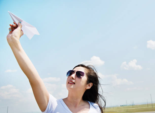 istock Woman throwing a paper airplane 956906890