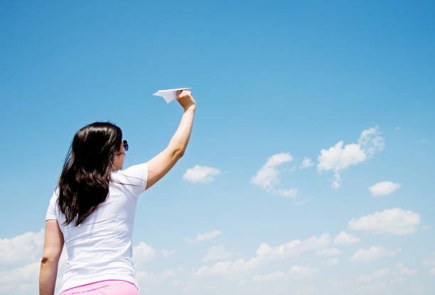 istock Woman throwing a paper airplane 956906982