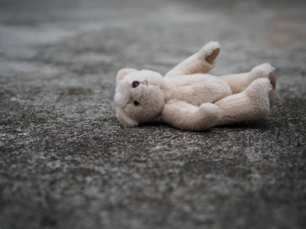 Teddy bear is laying down on the floor. lonely concept. international missing children's day. Teddy bear is laying down on the floor. lonely concept. international missing children's day. behavior teddy bear doll old stock pictures, royalty-free photos & images
