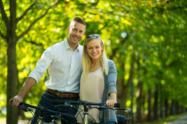istock portrait smiling young casual couple on bikes 956909398