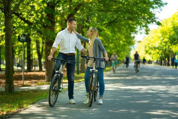 istock happy tourist couple on bikes in park 956910326