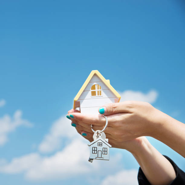 istock Woman hand holding a house model 956910624