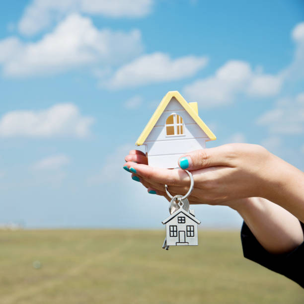 istock Woman hand holding a house model 956910662