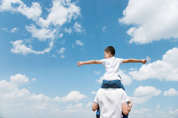 istock Son and father play paper airplane 956914788