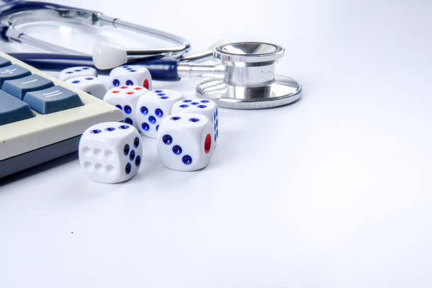 istock Close-Up Of Stethoscope With Calculator And Dice Over White Background 956916042