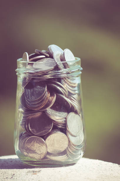 istock Close-Up Of Coins In Jar On Table 956920796