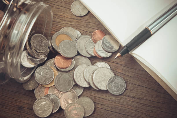 istock Close-Up Of Coins With Book On Table 956923792