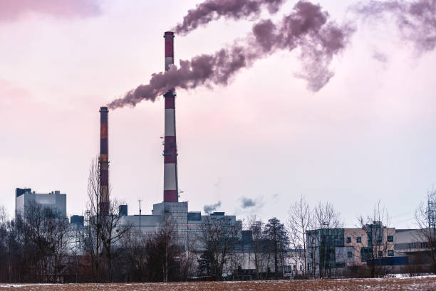 istock two factory pipes with smoke on sunset 956925334