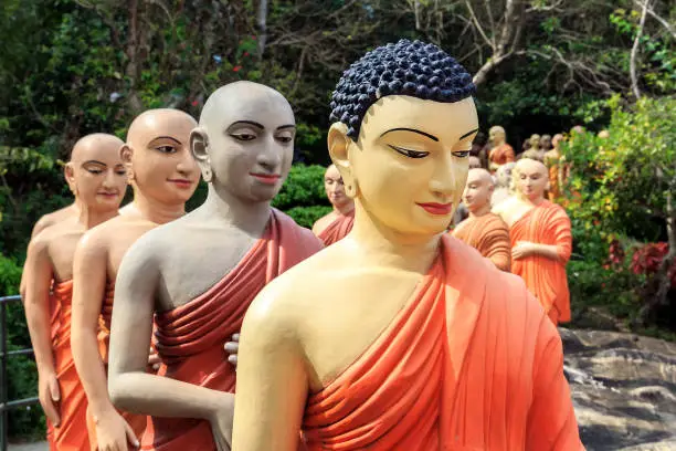 Statues of Buddhist monks standing in line to worship the Buddha. Closeup