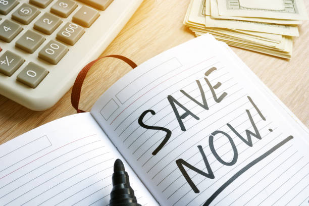 istock Words save now at a page. Savings concept. 956926118