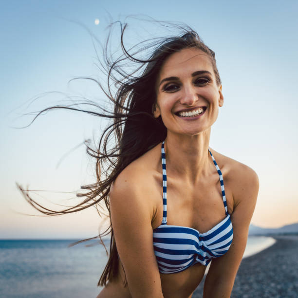 istock Woman on a pebble beach 956926918