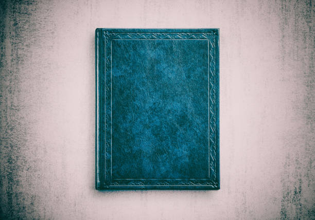 istock mock up book blue color on grunge background close-up, top view 956935898