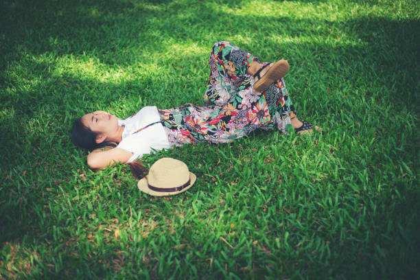 istock Young woman lying down on grass. relax time. 956943056
